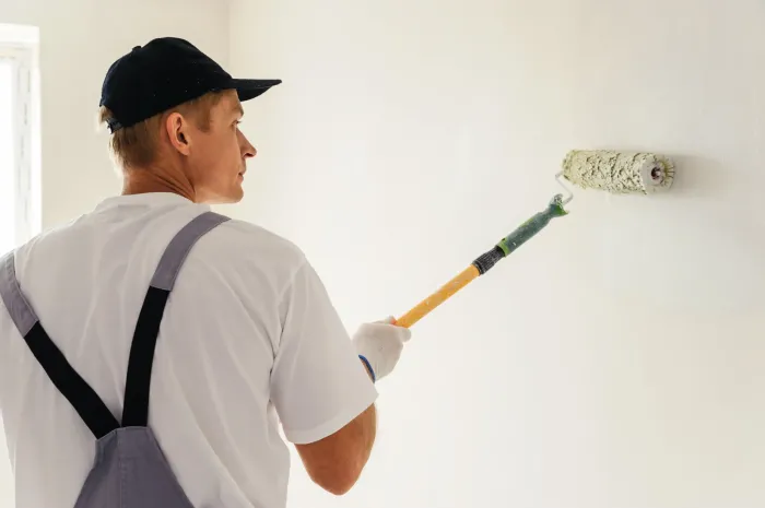 Artisan peintre traitant un plafond humide avant peinture